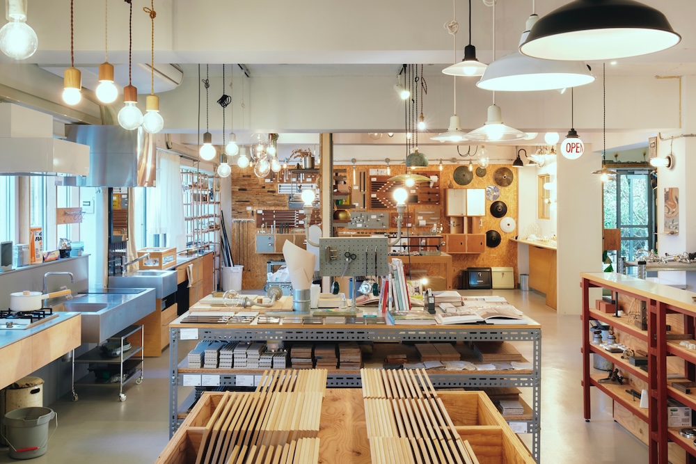 Bright workshop or maker-space showroom with wooden boards, tools, and shelves arranged for projects.